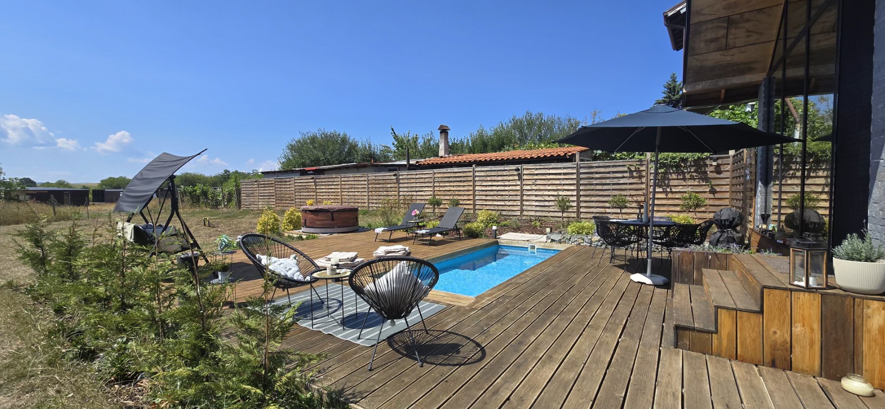 Pool deck with Acapulco chairs and countryside views at Villa Selya